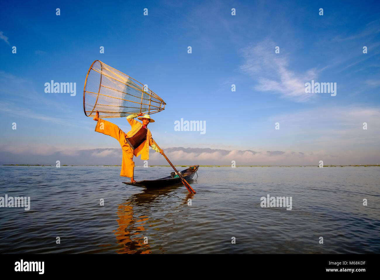Ein Fischer, stehend auf seinem Boot, posierend, Angeln ist die traditionelle Art und Weise auf dem Inle See Stockfoto