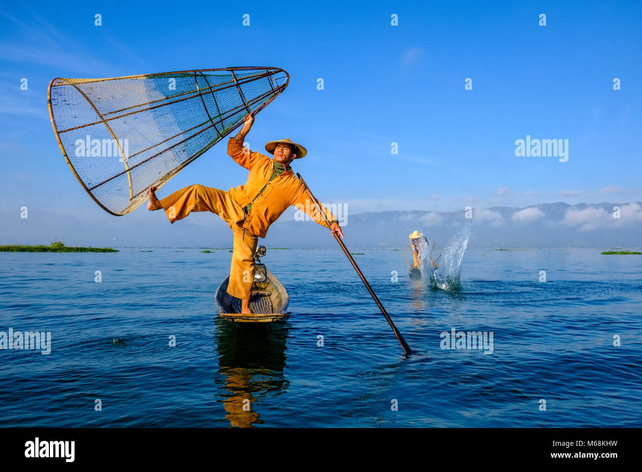 Zwei Fischer, stehend auf ihren Booten, posierend, fischen die traditionelle Art und Weise auf dem Inle See Stockfoto