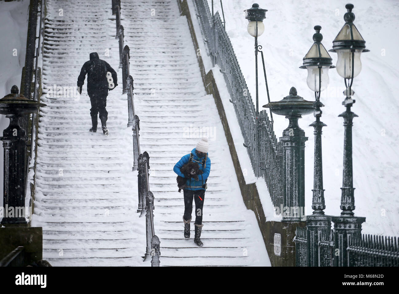 Menschen auf Edinburgh's Playfair Schritte im Schnee, Sturm Emma, vom Atlantik rollen, sieht balanciert, das Tier aus dem Osten kühl Russland Luft zu begegnen - weiter verbreitet Schneefall und bitteren Temperaturen. Stockfoto
