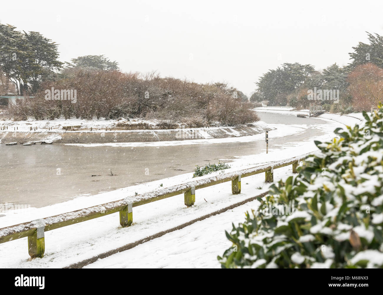 Schnee und Eis auf einem zugefrorenen See im Winter in Mewsbrook Park, Littlehampton, West Sussex, England, UK. Stockfoto