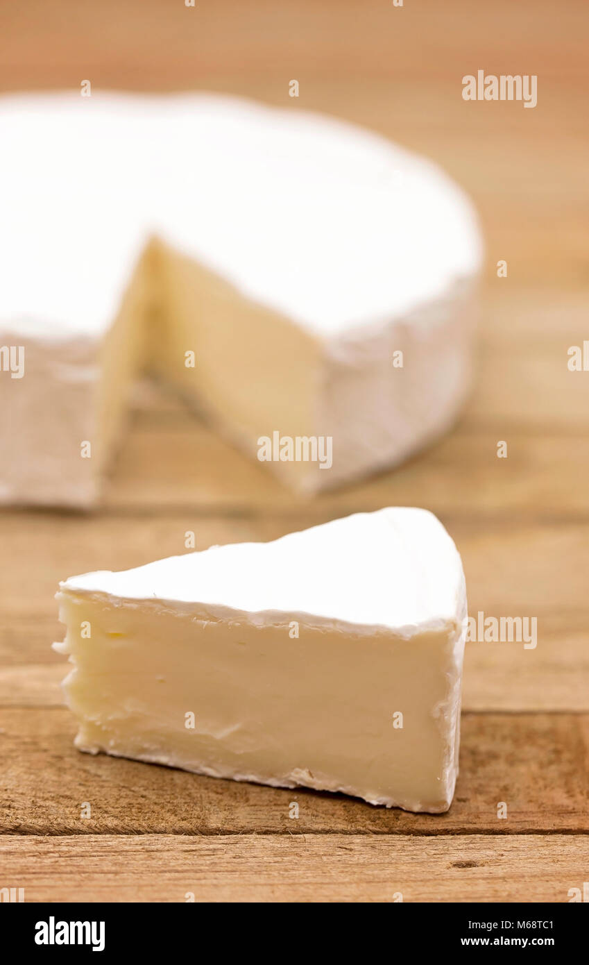 Schöne weiße runde Weiche Käse auf einem Holztisch Stockfoto