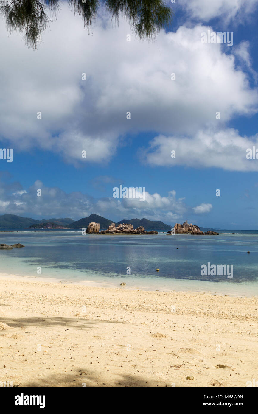 Einsamen tropischen Strand auf La Digue, Seychellen, mit Blick auf die Nachbarinsel Praslin. Stockfoto