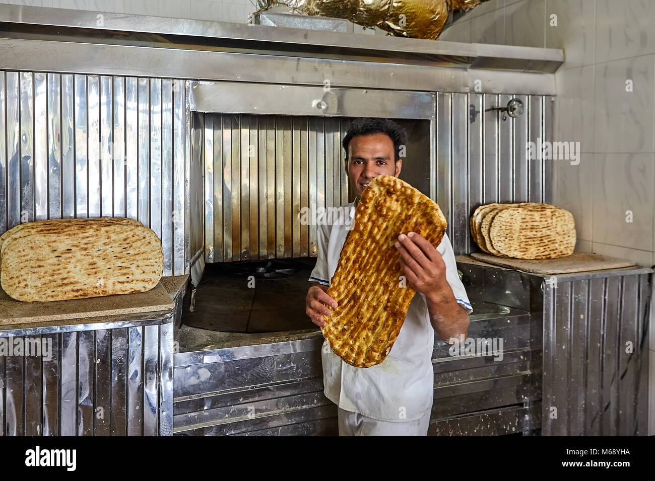 Kashan, Iran - April 27, 2017: Ein junger Bäcker zeigt Iranische Fladenbrot barbari, in der Bäckerei. Stockfoto