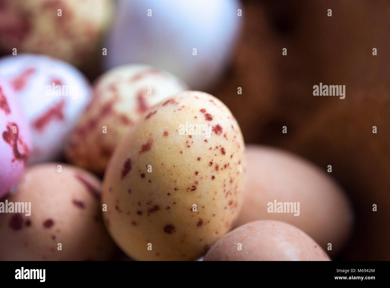 Close Up (Makro) schoß der Kleinen. gefleckt eiförmige Ostern Süßigkeiten in verschiedenen Farben mit Soft Focus Hintergrund. Stockfoto