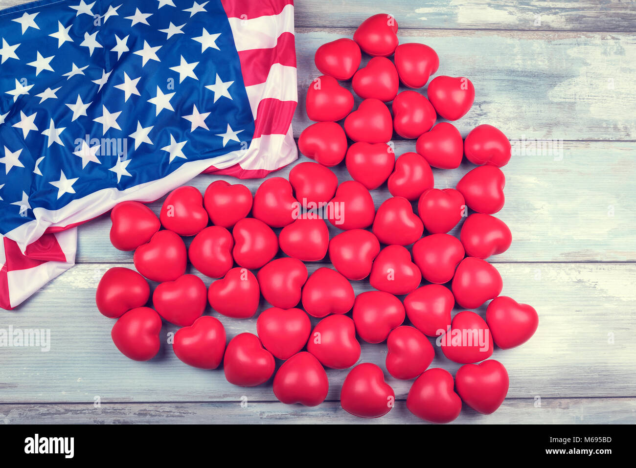 50 rote Herzen und die amerikanische Flagge auf einem hölzernen Oberfläche Stockfoto