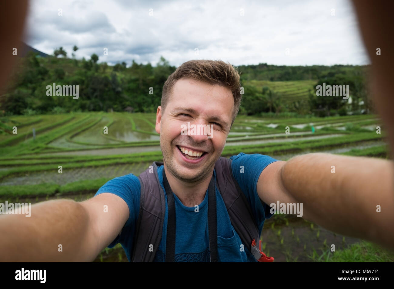 Happy kaukasischen Mann mit Rucksack Reisen in reis plantage und selphie Stockfoto