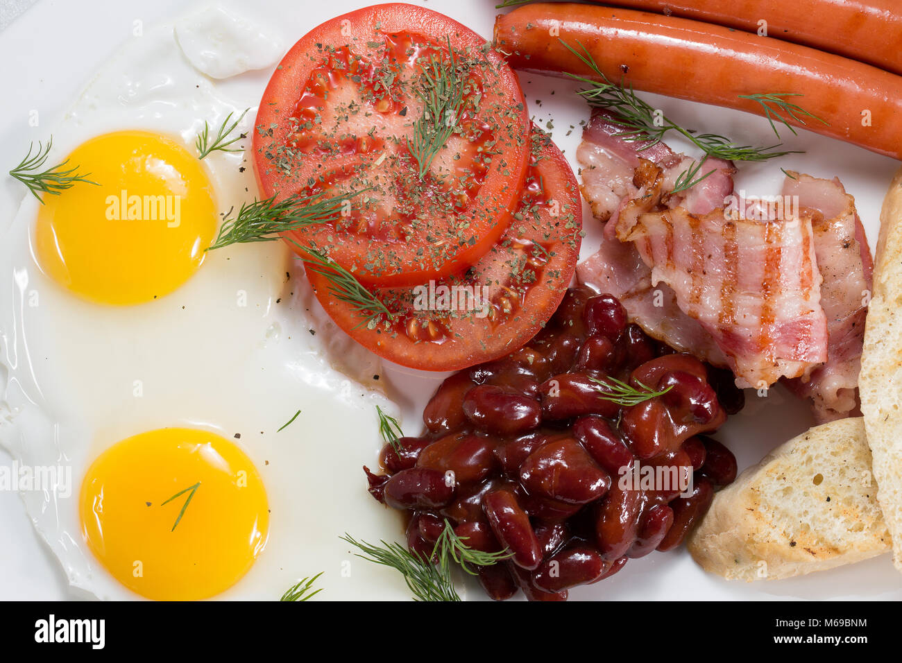 Englisches Frühstück mit Eiern, Bohnen, Speck und Würstchen. Stockfoto