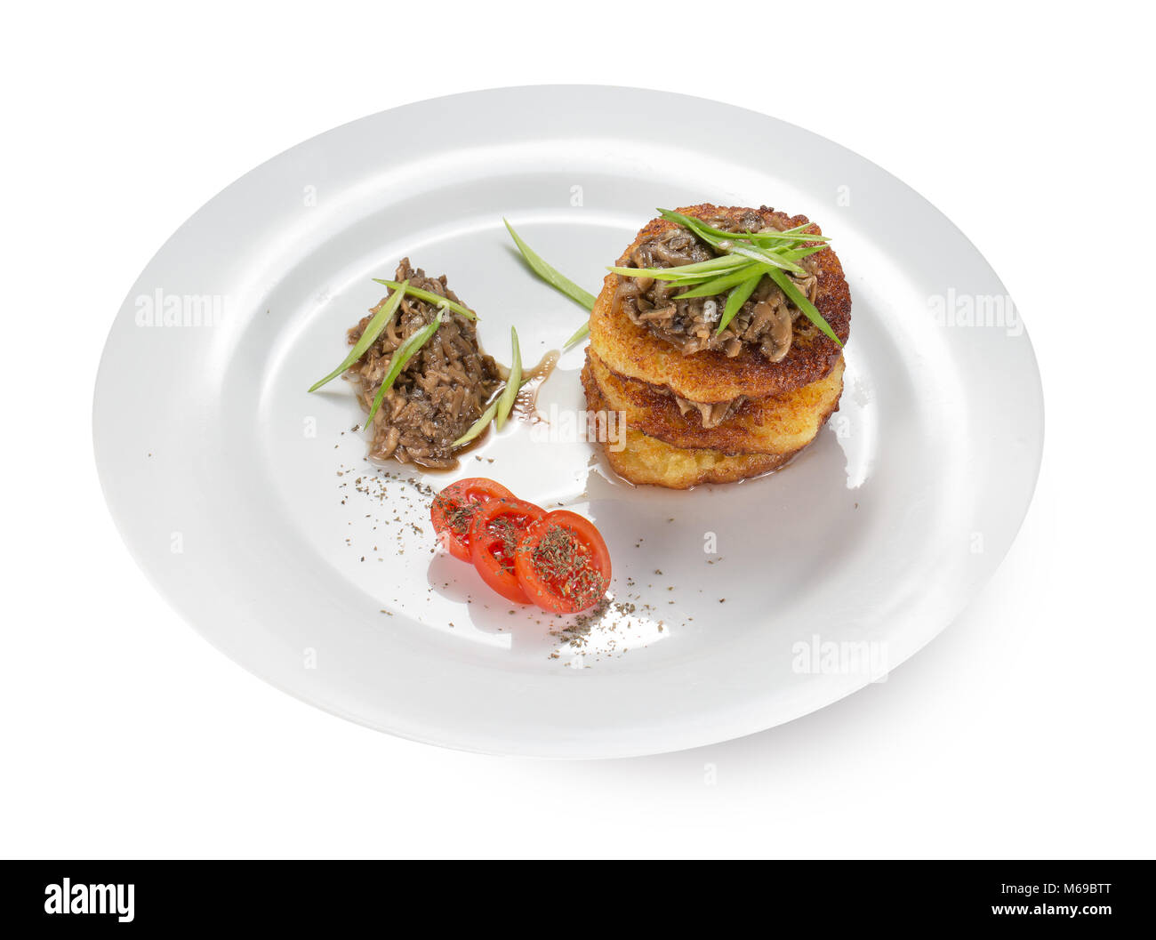 Kartoffelpuffer mit Pilzen auf einem Teller. Stockfoto