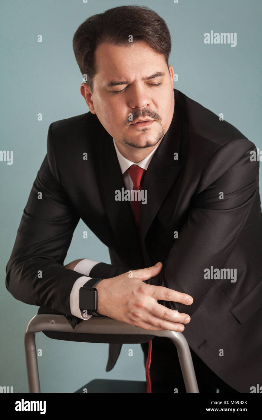 Portrait von Geschäftsmann, geschlossenen Augen und sind unglücklich. Innen-, Studio shot, von blauen oder grauen Hintergrund isoliert Stockfoto
