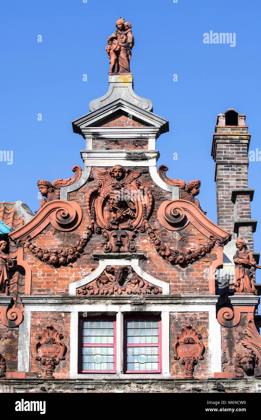 Flute Player/de Hel, Terracotta Skulpturen, Girlanden und Voluten dekorieren Giebel des 17. Jahrhunderts barocke Haus Fassade in der Stadt Gent, Belgien Stockfoto