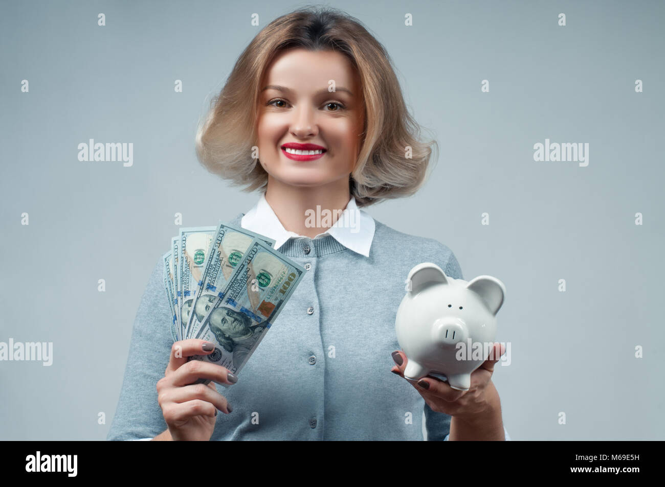 Frau mit Sparschwein und Bündel geld Banknoten. Finanzielle Einsparungen, intelligente Investition Konzept Stockfoto