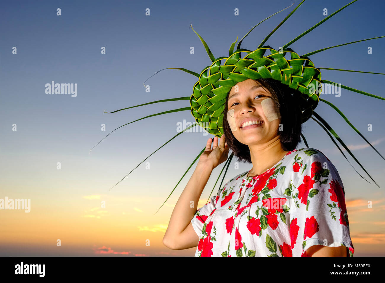 Porträt eines lächelnden schöne junge Frau mit Hut von Palm Blätter und Thanaka, die gelbe Teilfläche Paste Stockfoto