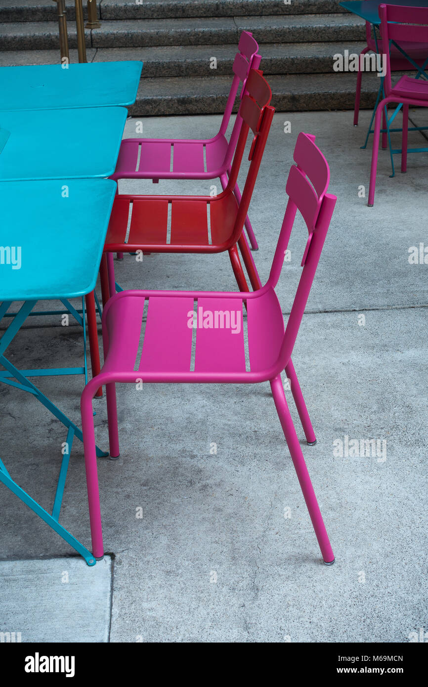 Rosa und roten Stühlen im Freien mit blauen Tabellen Stockfoto