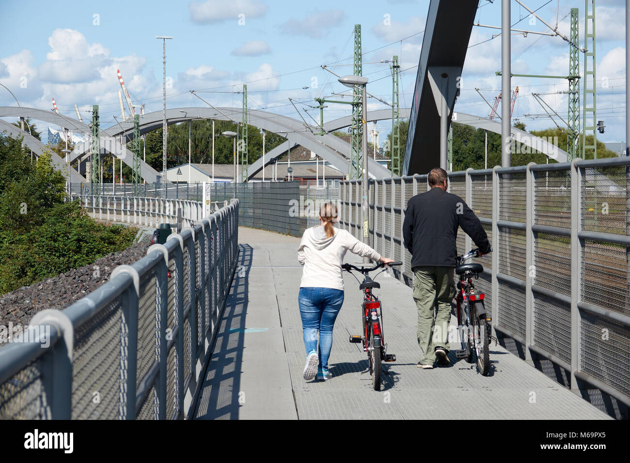 Ein Ehepaar zu Fuß mit dem Fahrrad auf einer Brücke. Stockfoto