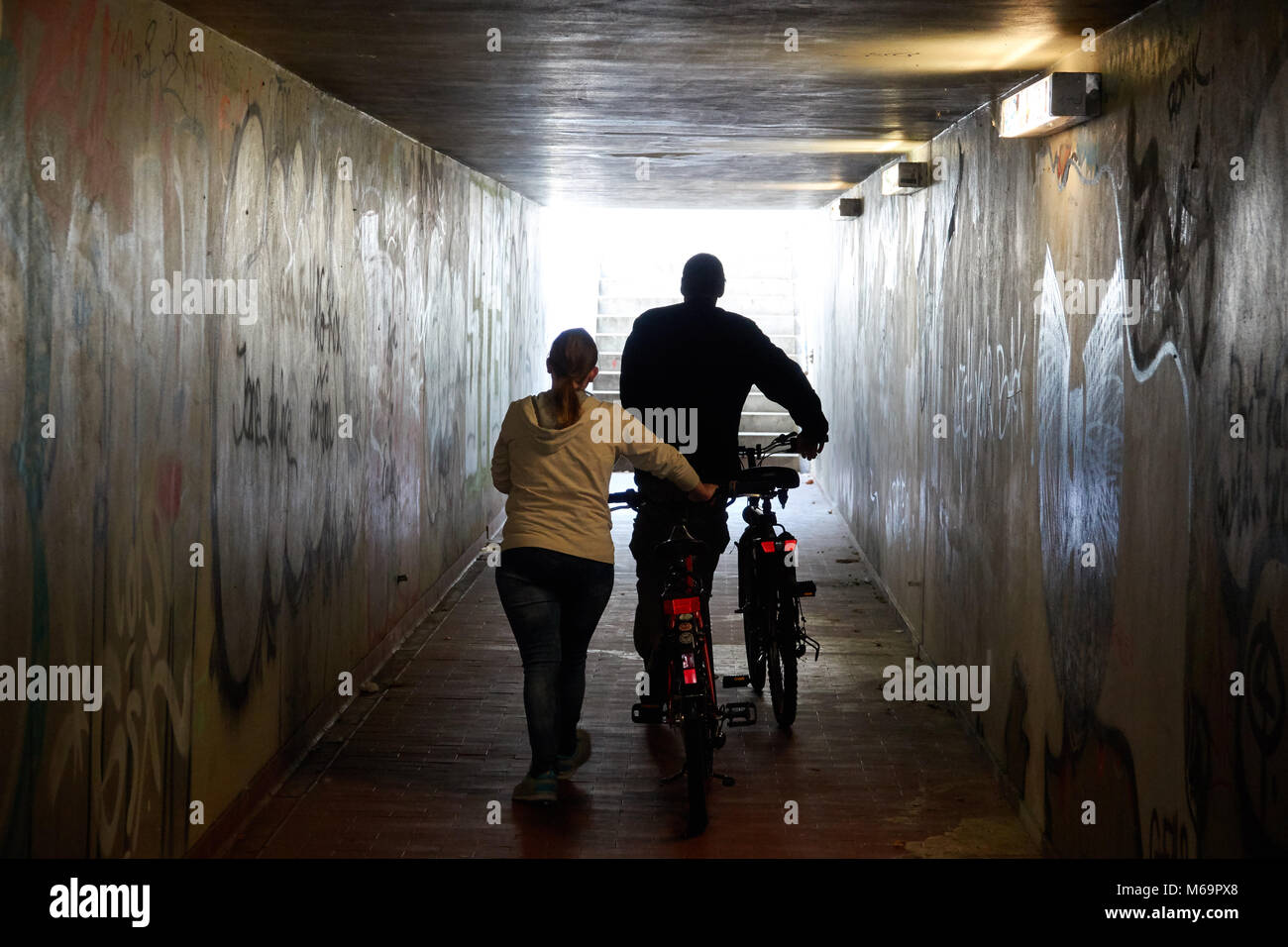 Ein Mann und eine Frau mit dem Fahrrad entlang der U-Passage. Stockfoto