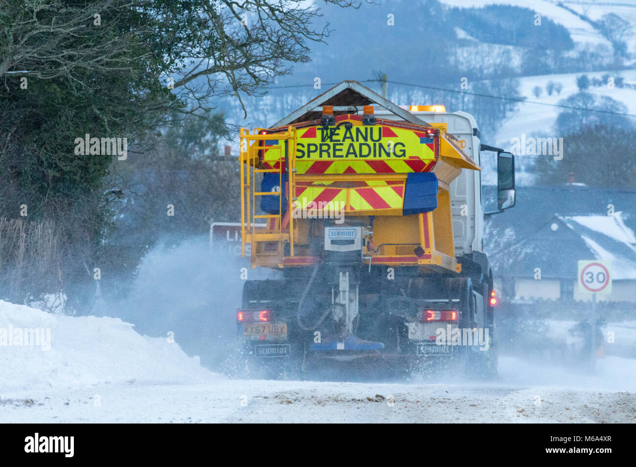 Ein Flintshire Rat knirschen Fahrzeug und Schneepflug Clearing der Hauptstraße in der Ortschaft Lixwm abgeschnitten wegen Schnee vom Sturm Emma und das Tier aus dem Osten arktische Luft masse aus Skandinavien, Flintshire, Wales Stockfoto