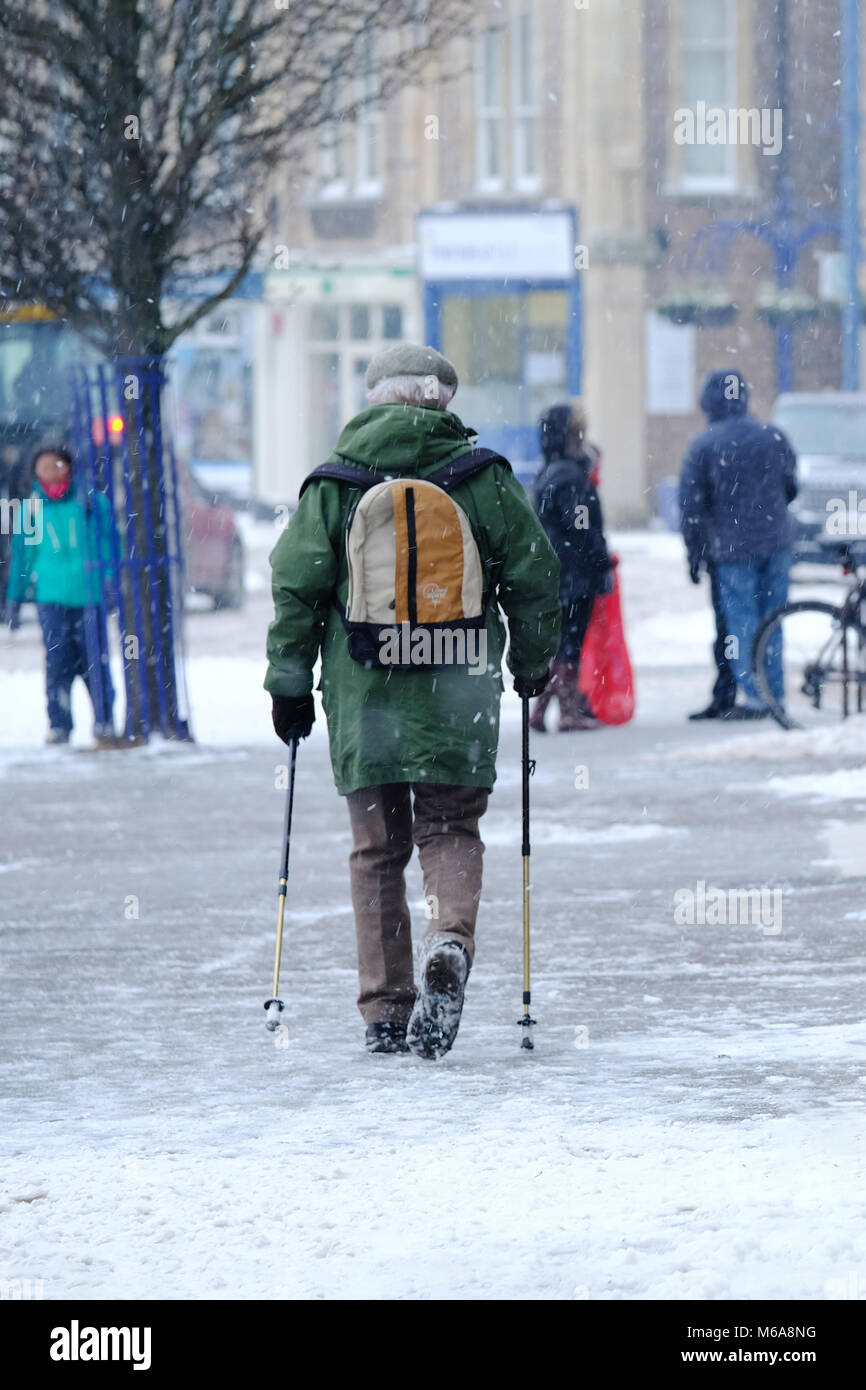 Portishead, Somerset, UK. 2. März, 2018. UK Wetter, Portishead, N. Somerset, Großbritannien Sturm Emma heute links tiefe Schneeverwehungen und eisigen Bedingungen in den Westen des Landes. Mehr Schnee ist für heute Nachmittag und eine gelbe Warnmeldung für mehr Schnee wird prognostiziert. Dieser ältere Mann seinen Weg durch die lokalen High St mit Hilfe von zwei Stöcken Credit: Stephen Hyde/Alamy leben Nachrichten Stockfoto