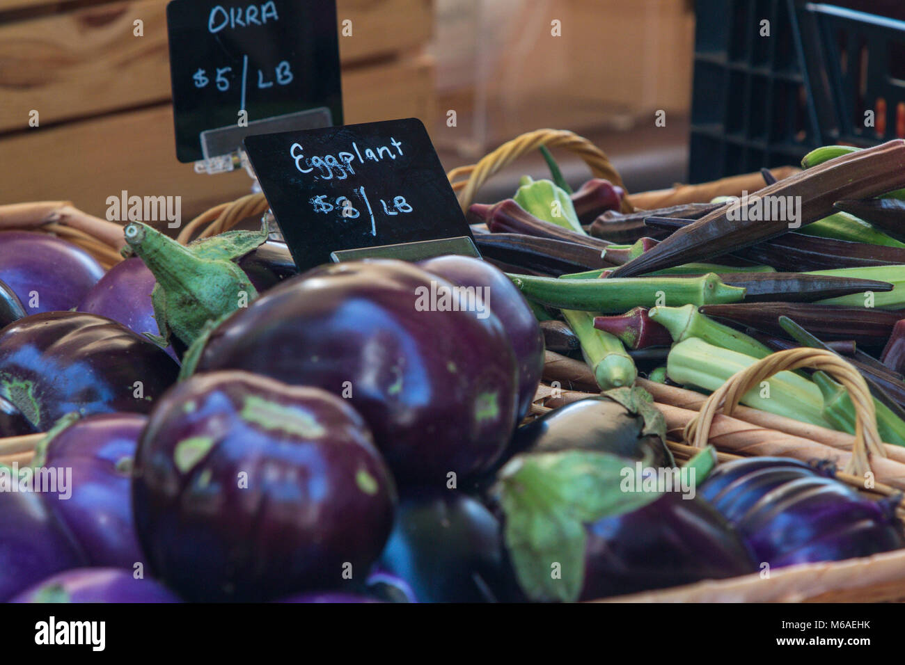 Aubergine und Okra auf Verkauf in Körben an einem lokalen Farmers Market. Stockfoto