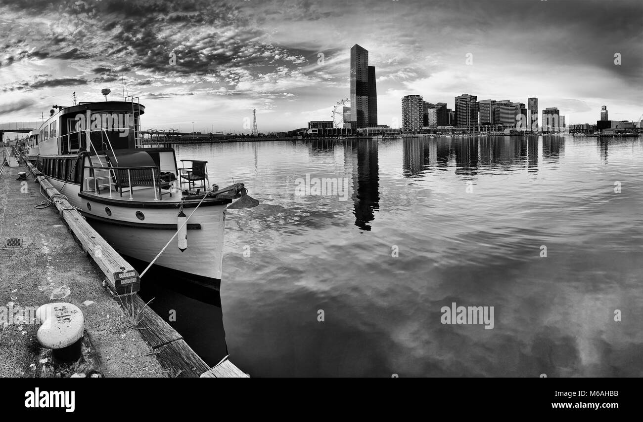 Moody bezauberndes Panorama von Melbourne Docklands mit Angedockten historisches Holzboot und entfernten modernen städtischen Türme reflektieren, noch Wasser von Yar Stockfoto