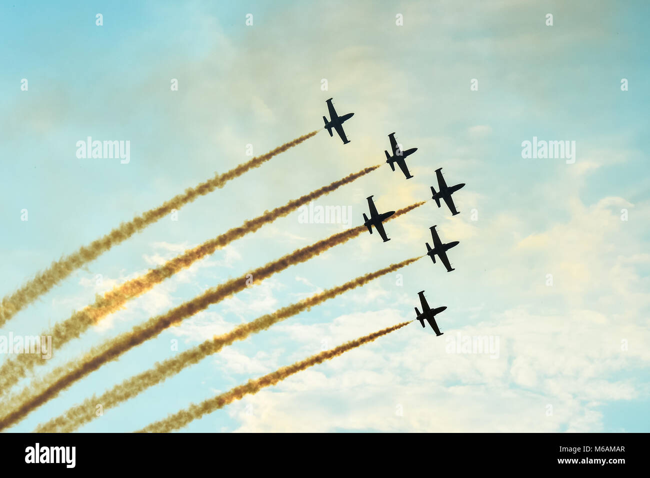 Akrobatische Flugzeuge tun Akrobatik an einer Flugschau bei Sonnenuntergang/Dämmerung fliegen Stockfoto
