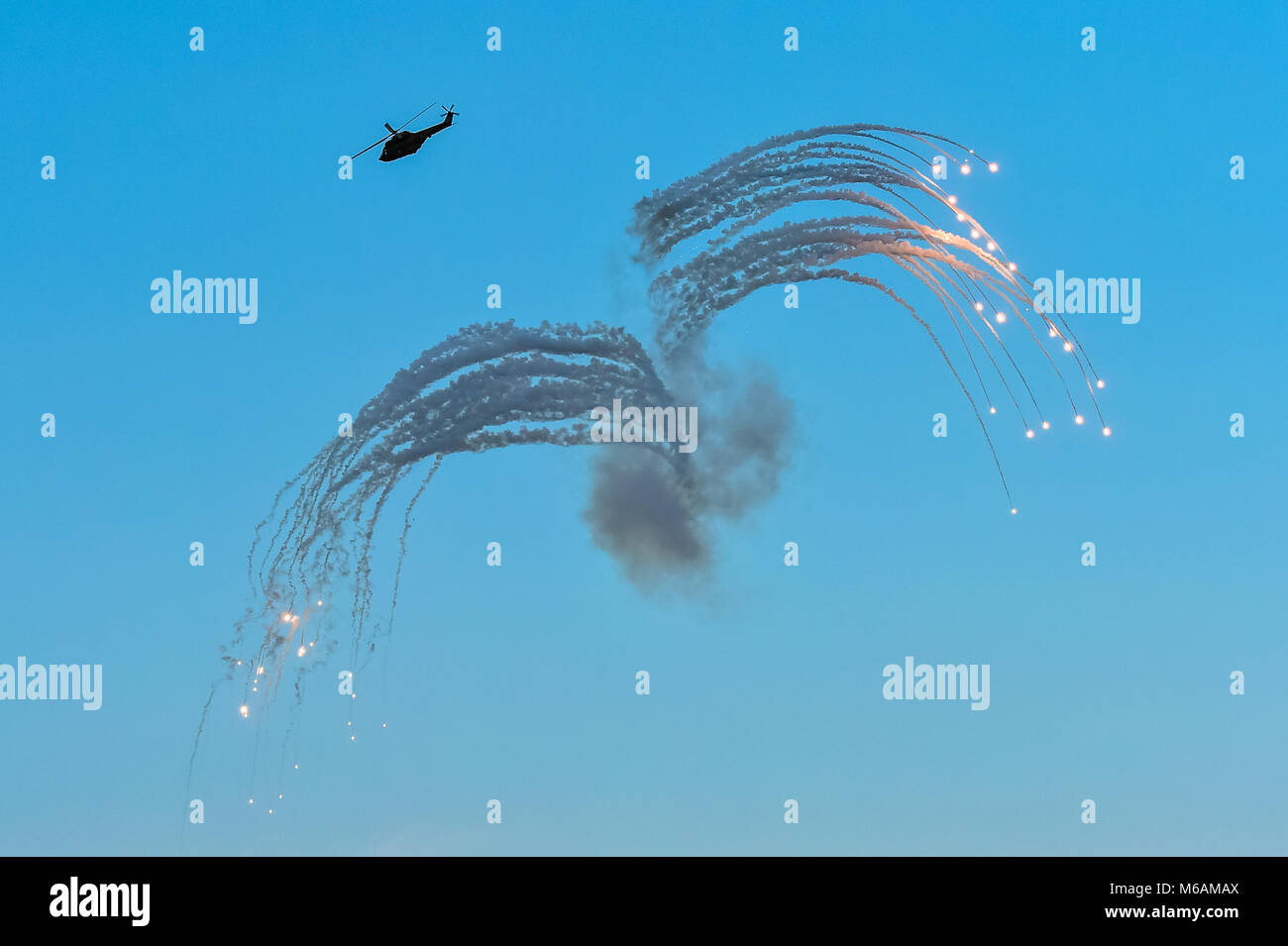 Militärische Hubschrauber in Aktion, Raketen Flares bei einer Flugschau Stockfoto