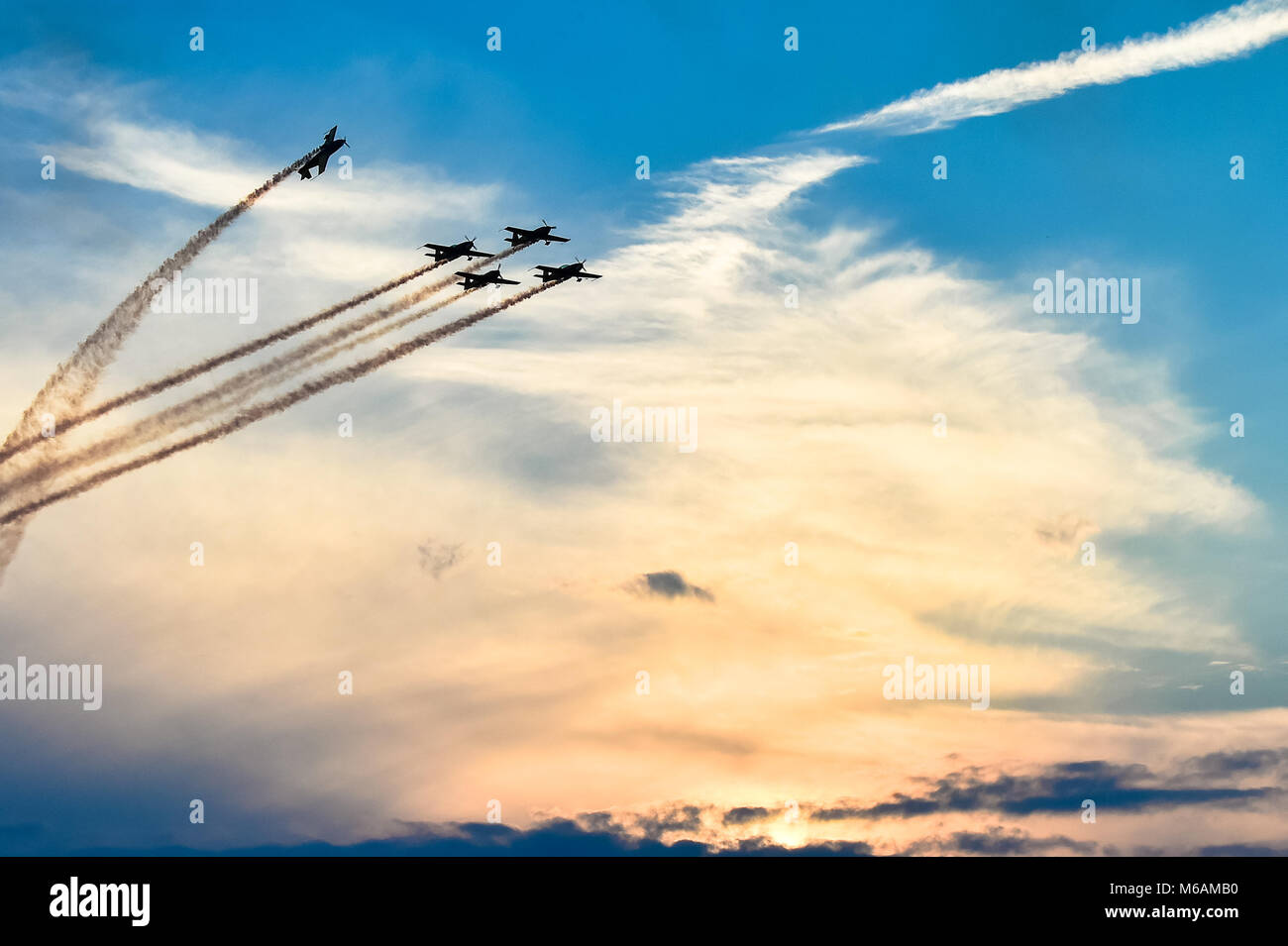 Akrobatische Flugzeuge in der Tätigkeit an einer Flugschau bei Sonnenuntergang/Dämmerung fliegen Stockfoto