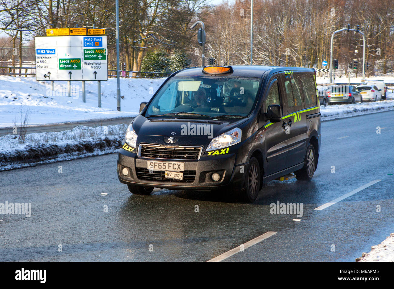 Schwarze Taxi fahren im Winter mit Schnee auf der Fahrbahn Stockfoto