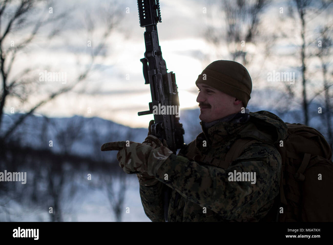 Marine mit Marine Rotational Force-Europe beobachtet seine Marines eine lange - Abstand einfügen Bewegung auf Skiern im Bereich Ausbildung übung Teil der Übung weiß Claymore in der Nähe von Bardufoss, Norwegen, 13. Februar 2018. Weiß Claymore ist einer in Großbritannien Royal Marines - LED-Training in Nordnorwegen, auf Winter Kriegsführung, einschließlich Schulung auf Bewegung im negativen Terrain und über Schnee konzentriert, und die Ausbildung in defensive und offensive Operationen bei winterlichen Bedingungen. (U.S. Marine Corps Stockfoto
