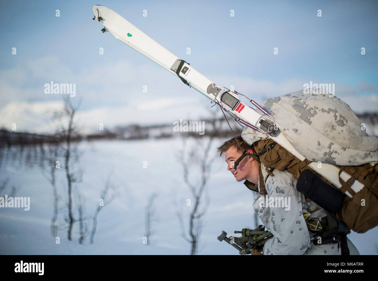 Marine mit Marine Rotational Force-Europe fährt in Position vor der Durchführung einer bergigen Angriff auf feindliche Position während der Bereich Ausbildung übung Teil der Übung weiß Claymore in der Nähe von Bardufoss, Norwegen, 15. Februar 2018. Weiß Claymore ist einer in Großbritannien Royal Marines - LED-Training in Nordnorwegen, auf Winter Kriegsführung, einschließlich Schulung auf Bewegung im negativen Terrain und über Schnee konzentriert, und die Ausbildung in defensive und offensive Operationen bei winterlichen Bedingungen. (U.S. Marine Corps Stockfoto