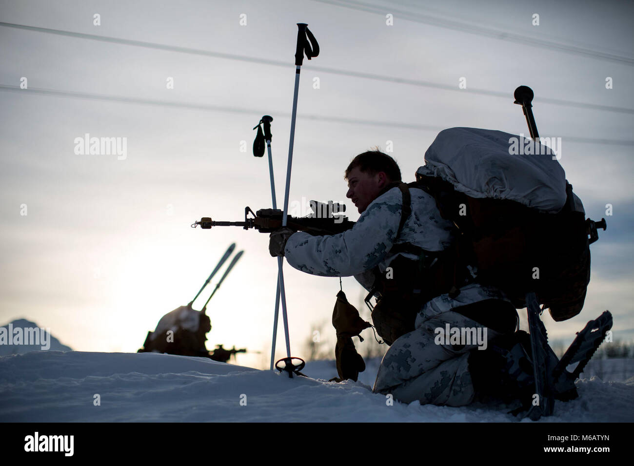 Marine mit Marine Rotational Force-Europe fährt in Position vor der Durchführung einer bergigen Angriff auf feindliche Position während der Bereich Ausbildung übung Teil der Übung weiß Claymore in der Nähe von Bardufoss, Norwegen, 15. Februar 2018. Weiß Claymore ist einer in Großbritannien Royal Marines - LED-Training in Nordnorwegen, auf Winter Kriegsführung, einschließlich Schulung auf Bewegung im negativen Terrain und über Schnee konzentriert, und die Ausbildung in defensive und offensive Operationen bei winterlichen Bedingungen. (U.S. Marine Corps Stockfoto
