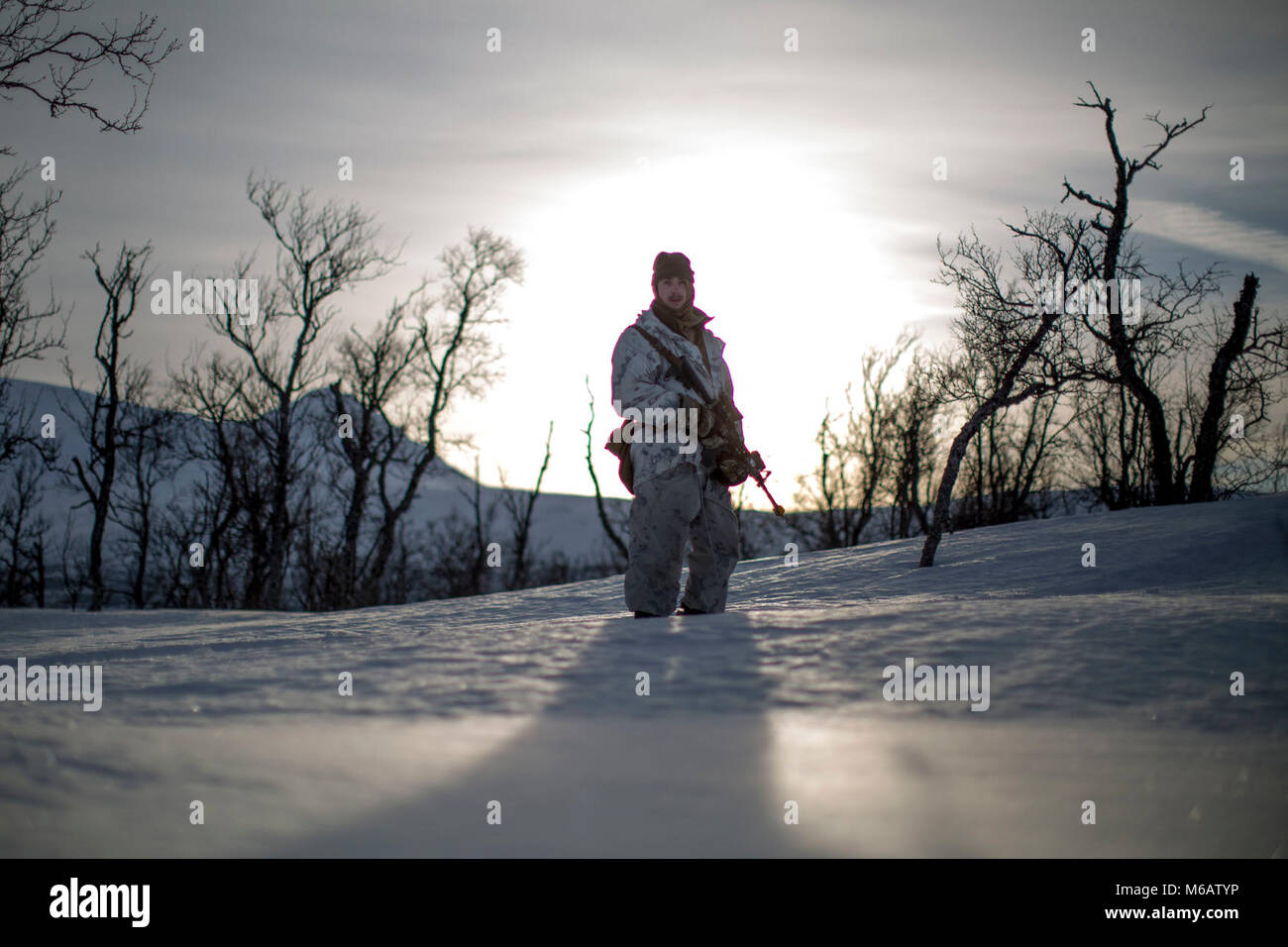 Marine mit Marine Rotational Force-Europe fährt in Position vor der Durchführung einer bergigen Angriff auf feindliche Position während der Bereich Ausbildung übung Teil der Übung weiß Claymore in der Nähe von Bardufoss, Norwegen, 15. Februar 2018. Weiß Claymore ist einer in Großbritannien Royal Marines - LED-Training in Nordnorwegen, auf Winter Kriegsführung, einschließlich Schulung auf Bewegung im negativen Terrain und über Schnee konzentriert, und die Ausbildung in defensive und offensive Operationen bei winterlichen Bedingungen. (U.S. Marine Corps Stockfoto