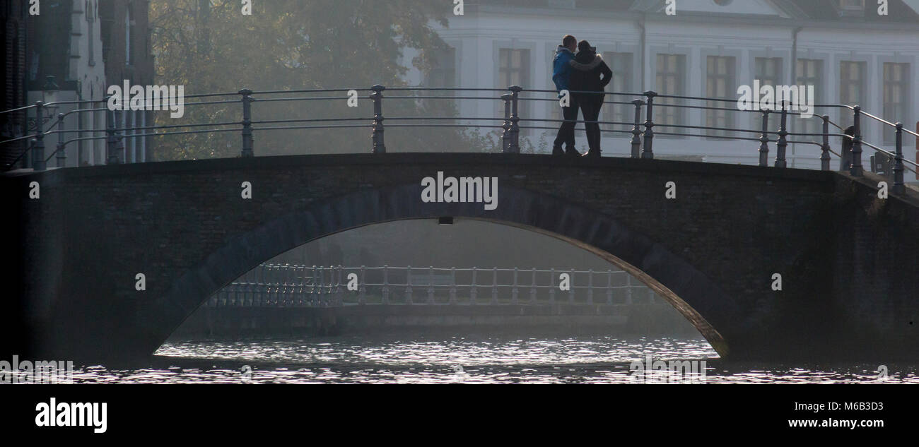 Paar auf einer Brücke über den Kanal von Brügge Silhouette Stockfoto