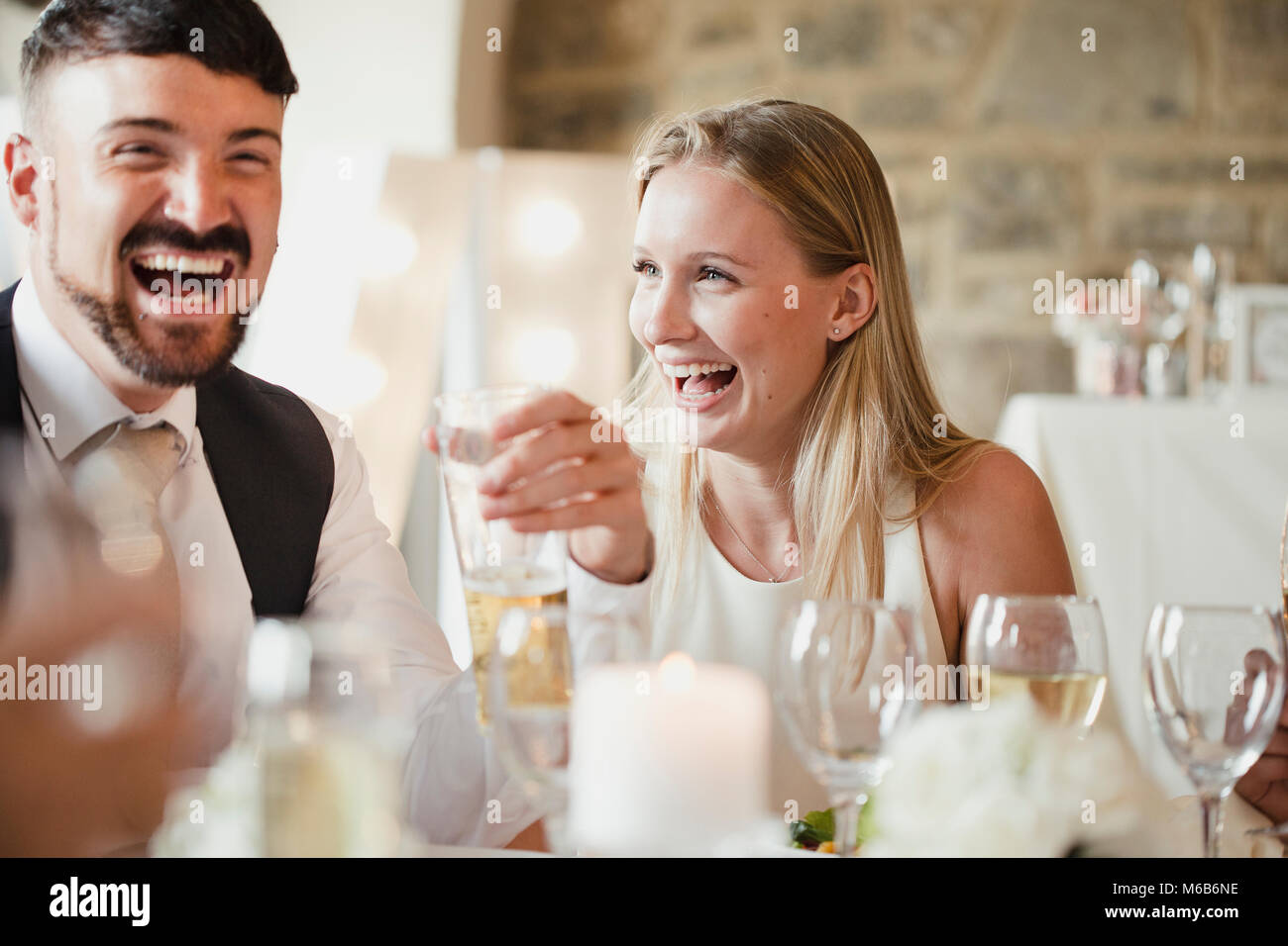 Hochzeit Gäste erfreuen sich am Tisch sitzen für die Mahlzeit. Sie reden und lachen und Wein trinken und Lager. Stockfoto