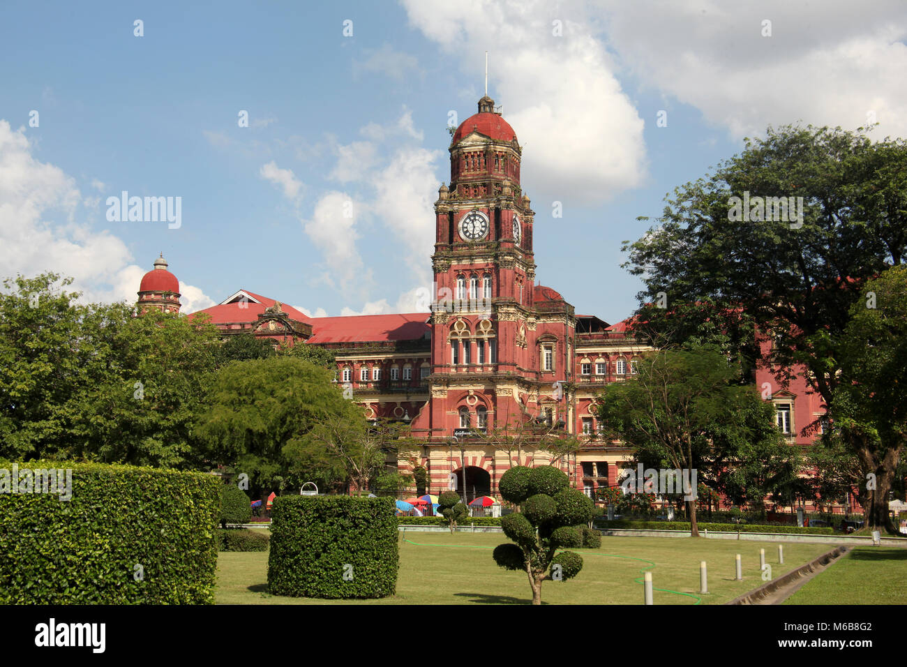 Ehemalige koloniale Gebäude aus rotem Backstein High Court mit dem Uhrturm, Yangon, Myanmar. Stockfoto