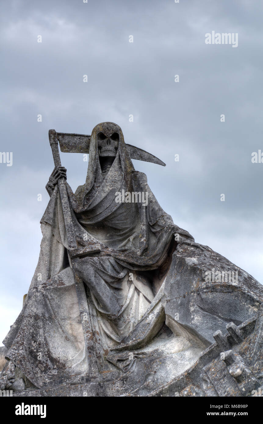 Der Tod personifiziert als Skelett mit Umhang und Sense dieses Bild der verwitterte Skulptur auf dem Friedhof getroffen wurde. Stockfoto