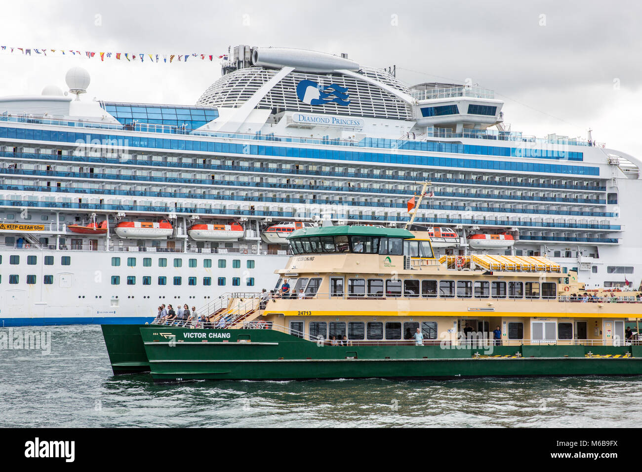 Die Sydney-Fähre MV Victor Chang passiert das Kreuzfahrtschiff Diamond Princess, das am Circular Quay, Sydney, festgemacht ist Stockfoto