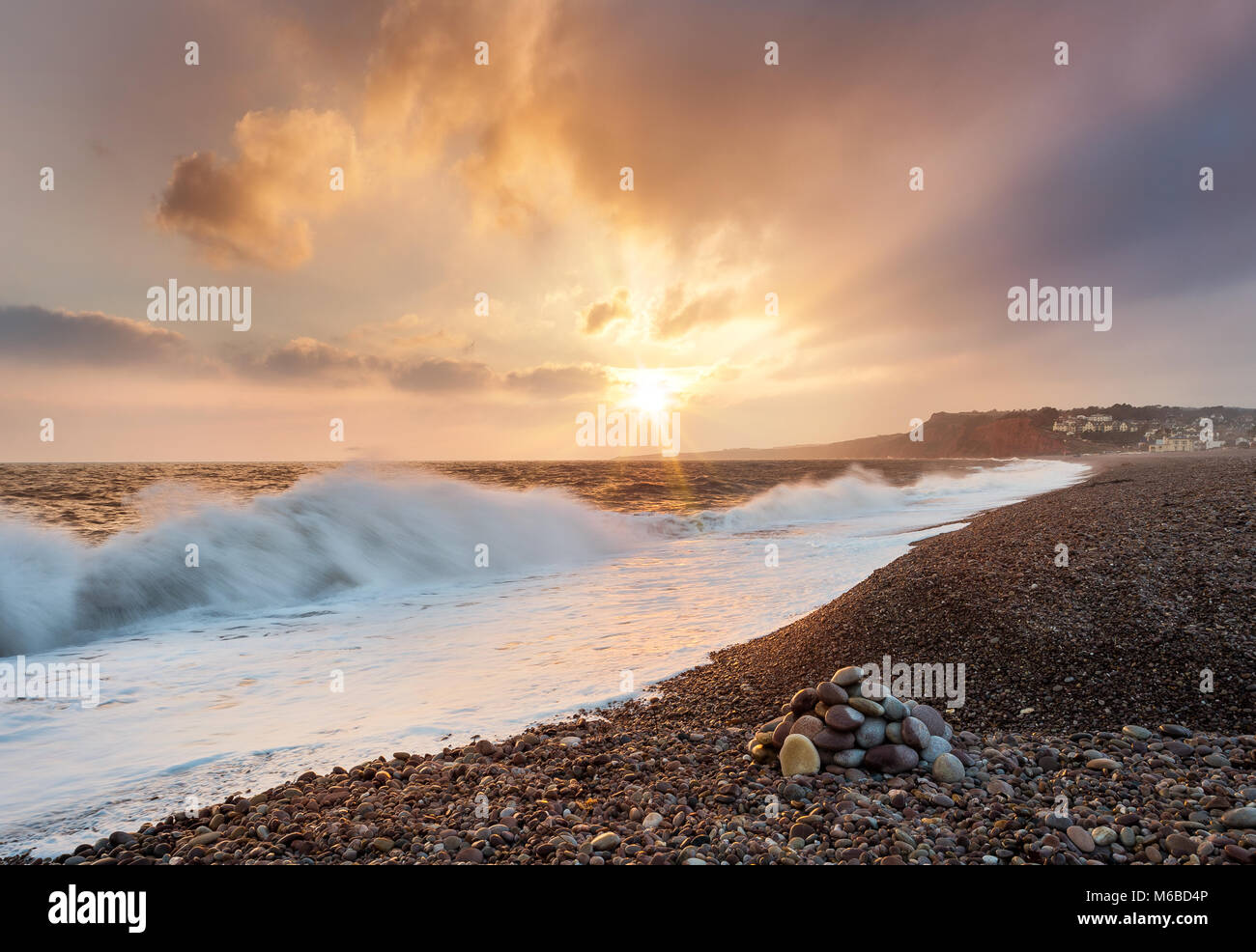 Sonnenaufgang und Wave Bruch über Steine bei Budleigh Salterton East Devon Stockfoto