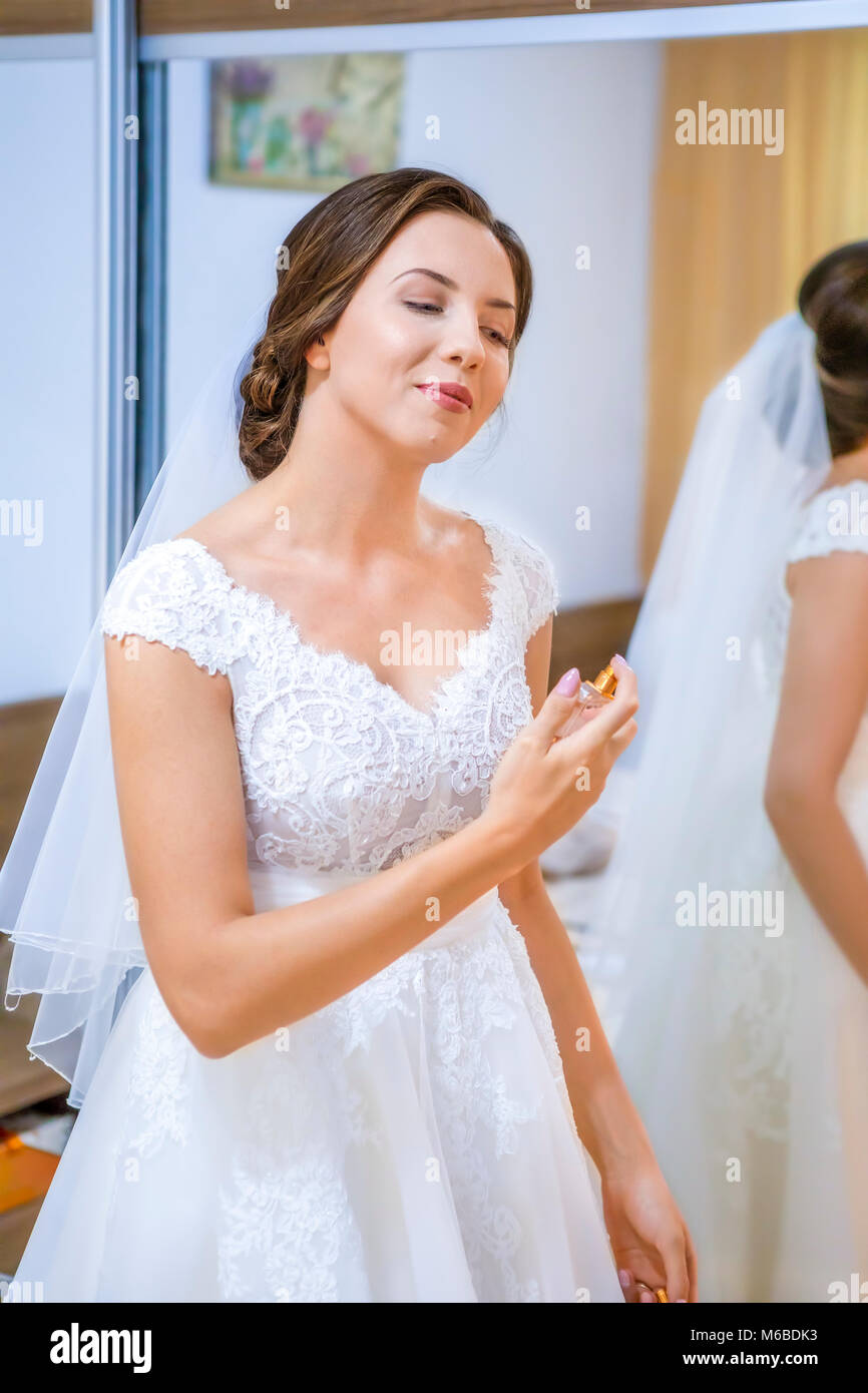 Klassische Porträt einer wunderschönen Braut auf einer Hochzeit morgen Holding Flasche Luxus perfum. Stockfoto