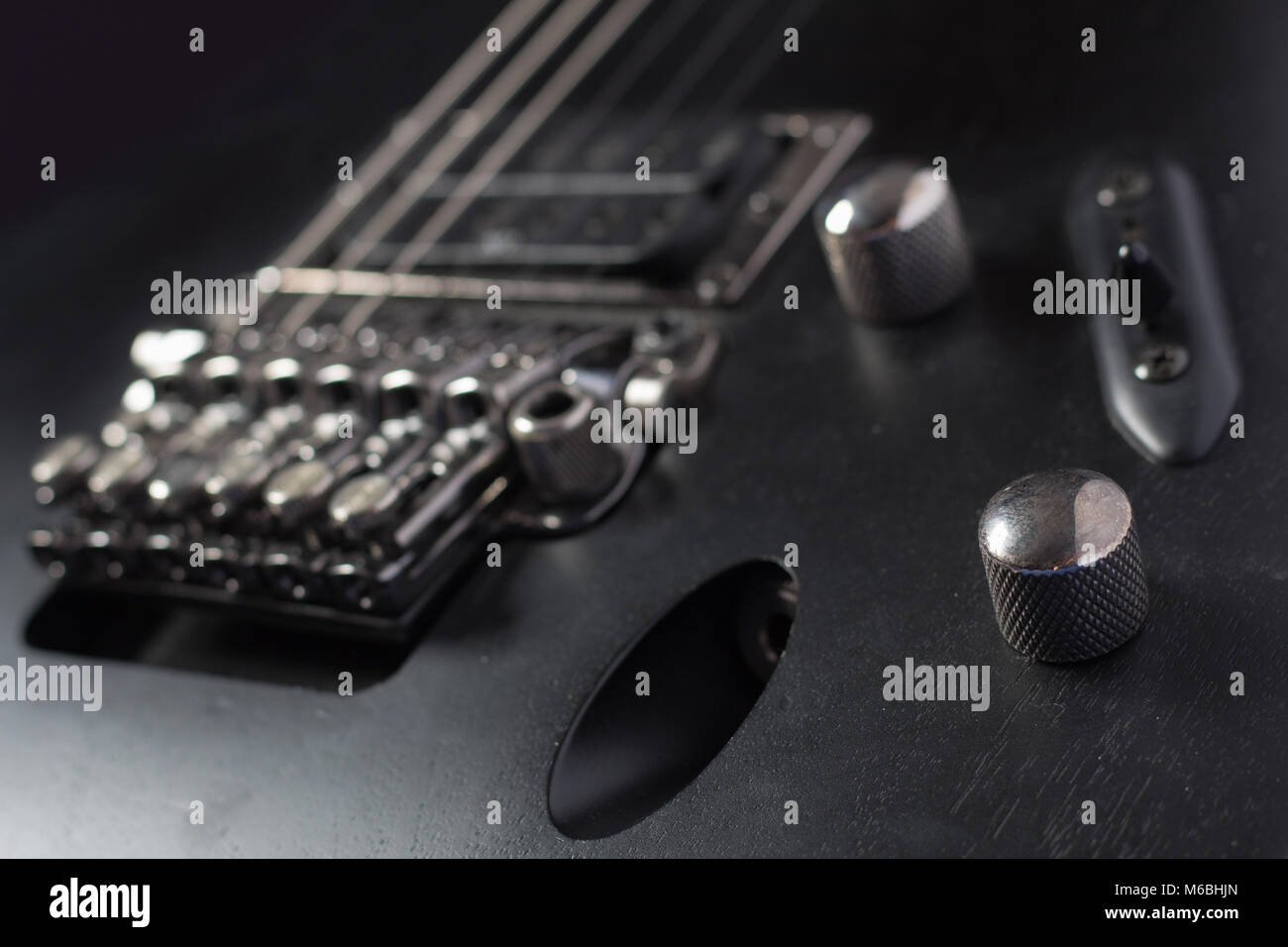 Matt Schwarz E-Gitarre Körper closeup, mit humbucker Pickup und Floyd Rose Style locking Tremolo. Flache konzentrieren. Stockfoto