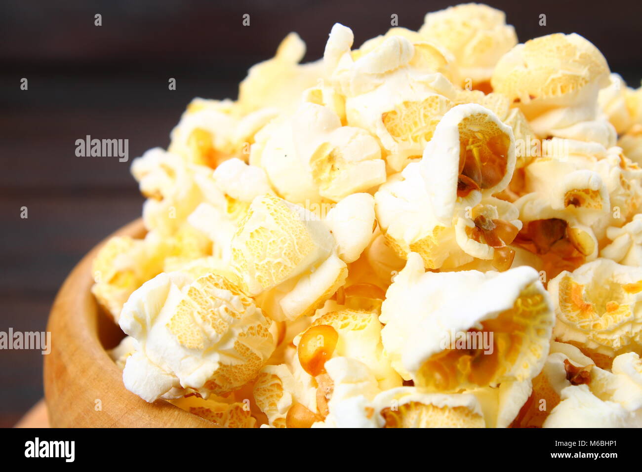 Gesalzene Popcorn in eine hölzerne Schüssel auf einen hölzernen Tisch Stockfoto