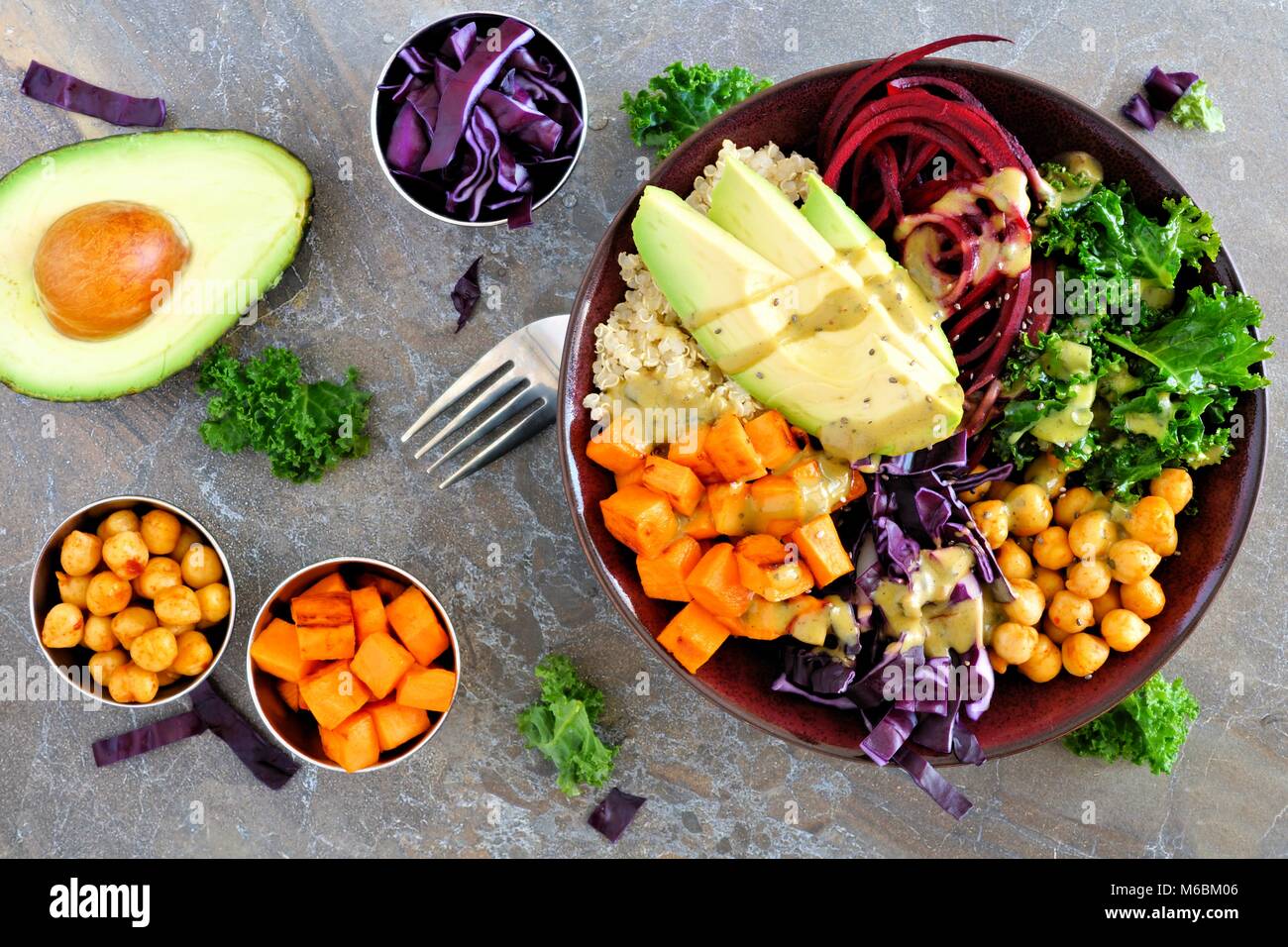 Buddha Schüssel mit Quinoa, Avocado, Kichererbsen, Gemüse auf einem dunklen Stein Hintergrund, gesunde Ernährung Konzept. Overhead Szene. Stockfoto