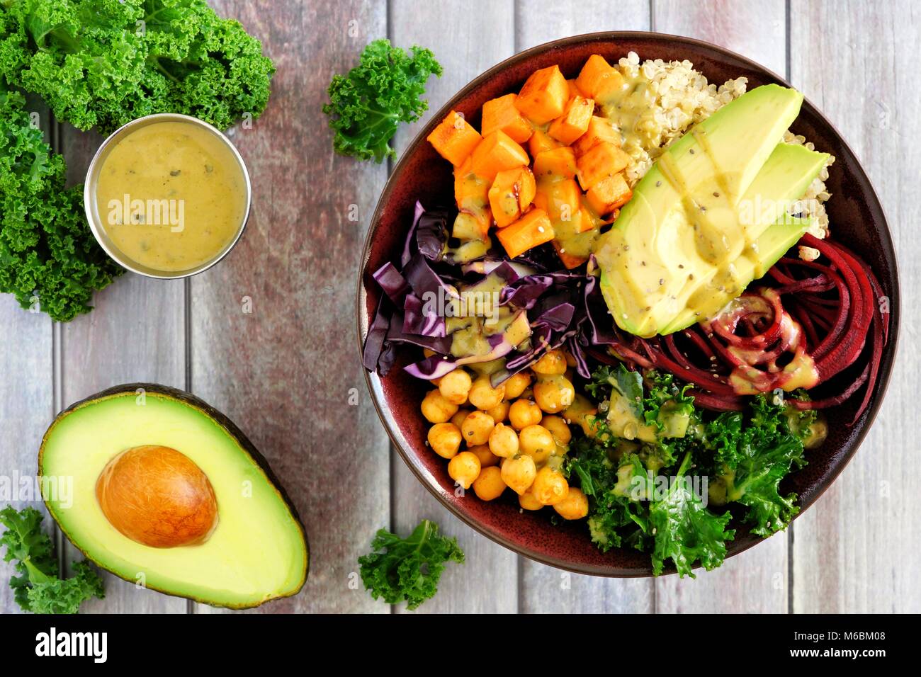 Buddha Schüssel mit Quinoa, Avocado, Kichererbsen, Gemüse auf einem Holz Hintergrund, gesunde Ernährung Konzept. Overhead Szene. Stockfoto