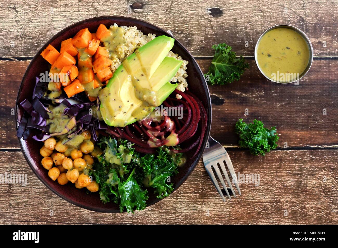 Buddha Schüssel mit Quinoa, Avocado, Kichererbsen, Gemüse auf einem Holz Hintergrund, gesunde Ernährung Konzept. Ansicht von oben. Stockfoto