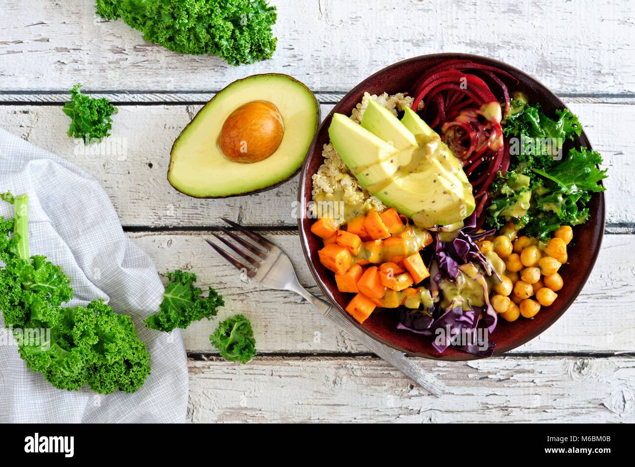 Buddha Schüssel mit Quinoa, Avocado, Kichererbsen, Gemüse auf einem weißen Holz Hintergrund, gesunde Ernährung Konzept. Ansicht von oben. Stockfoto