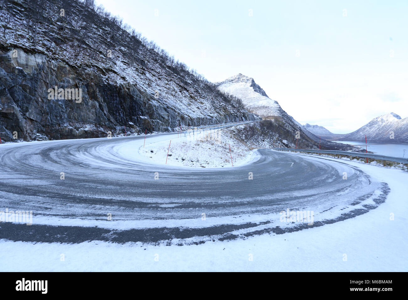 Eine verschneite Winterlandschaft gefährlich Mountain Road biegen in Norwegen Stockfoto