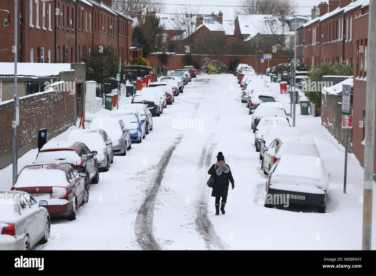 Eine Frau Mann ein Schnee Straße in Drumcondra, Dublin abgedeckt, extreme Wetterbedingungen fortgesetzt. Stockfoto