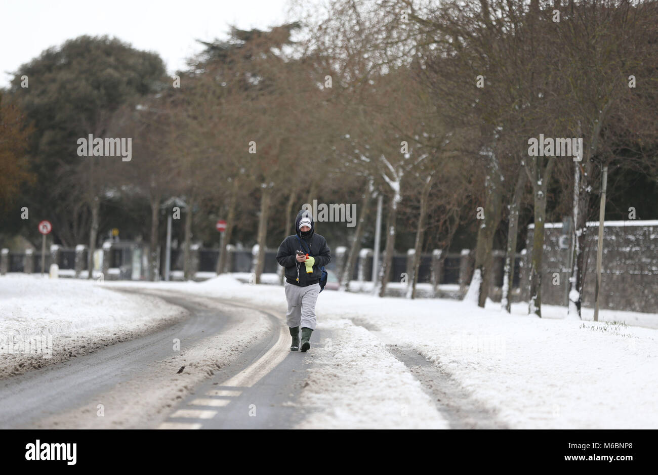 Ein Mann Spaziergänge entlang der Finglas Road, Dublin als extreme Wetterbedingungen fortgesetzt. Stockfoto