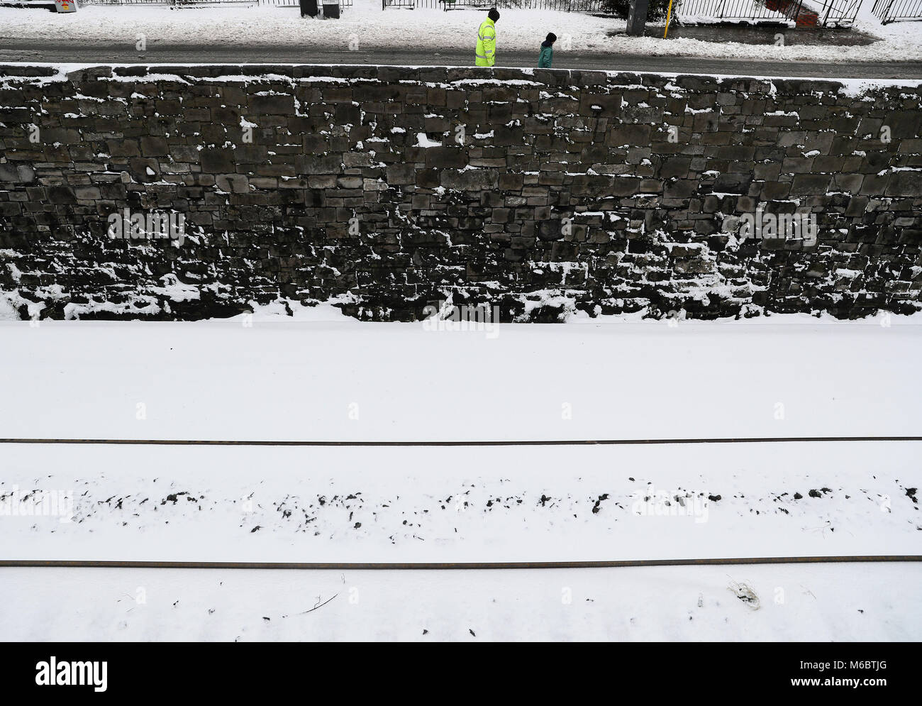 Menschen gehen vorbei an einem verschneiten Bahnlinie in Drumcondra, Dublin, wie die Wetterbedingungen fortgesetzt. Bild Datum: Freitag, März 2, 2018. Siehe PA Geschichte Wetter Schnee Irland. Photo Credit: Brian Gesetzlosen/PA-Kabel Stockfoto