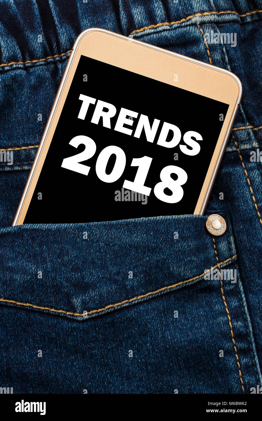 Trends 2018 Inschrift auf dem Telefondisplay. Vor jeans Tasche mit Trends Inschrift 2018 Smartphone. Stockfoto