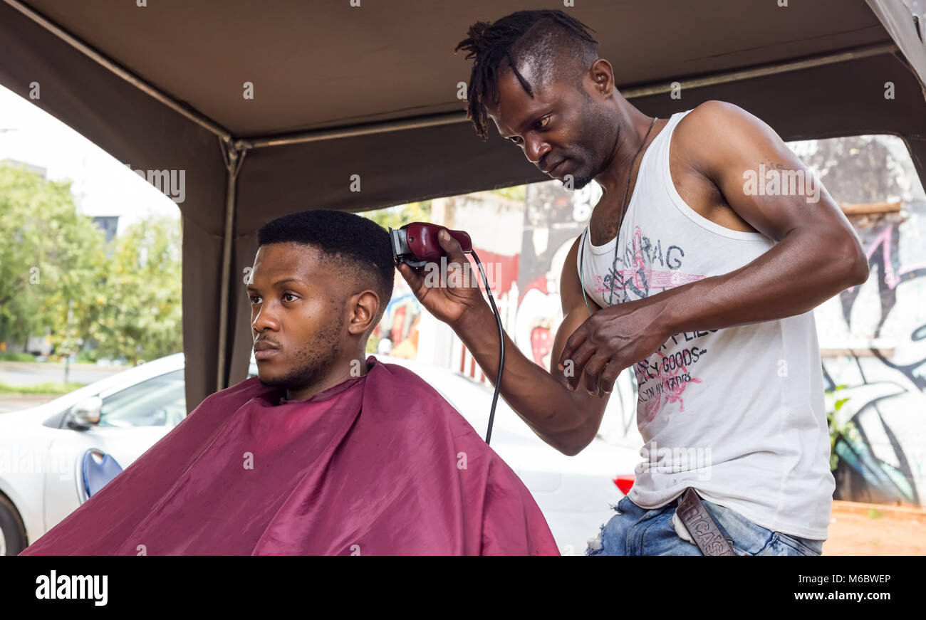 Mann, der Haarschnitt in einem informellen Friseur in Johannesburg. Stockfoto